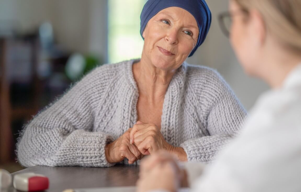 Senior woman with a small smile listening to her doctor