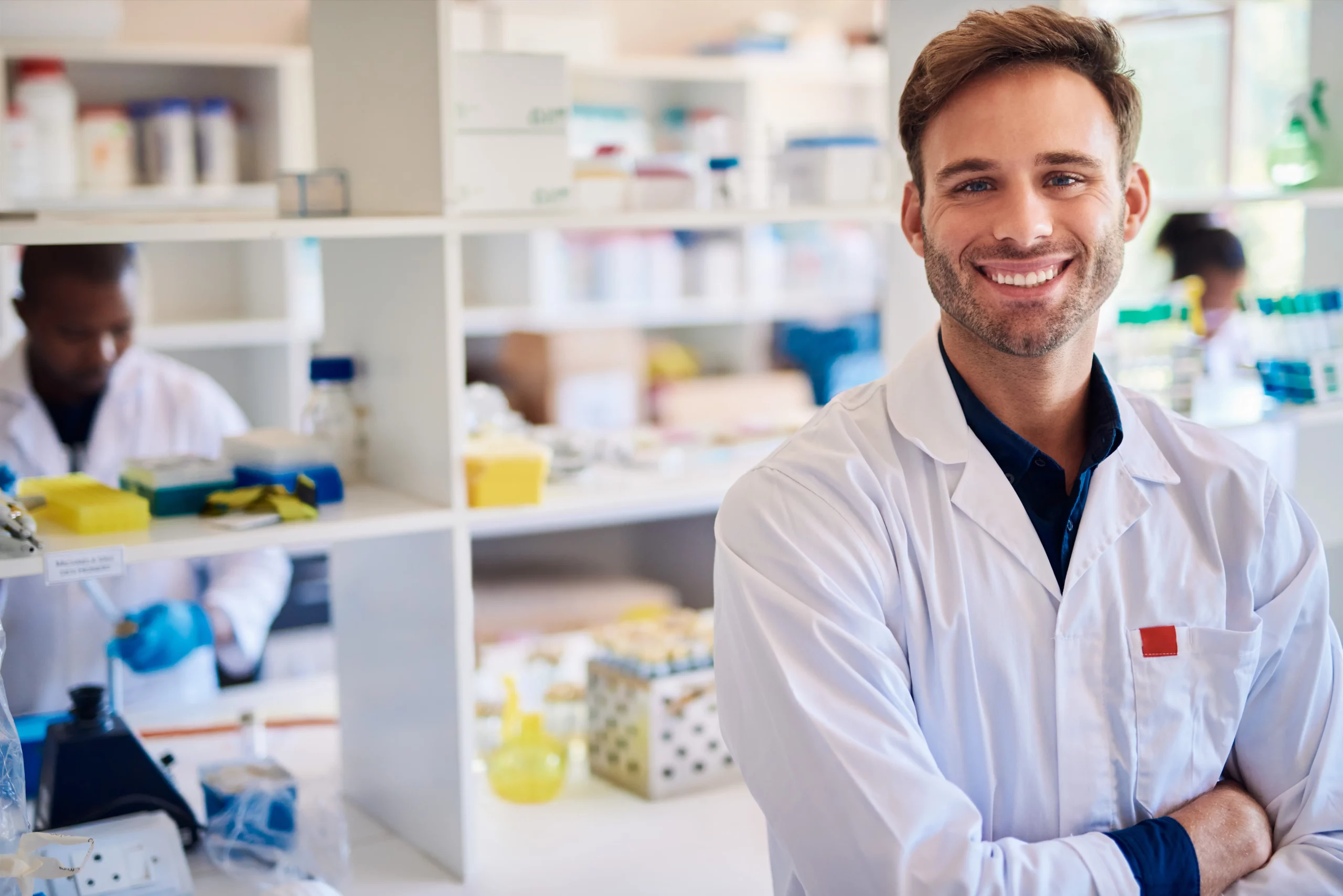 joven farmacéutico de brazos cruzados y sonriente