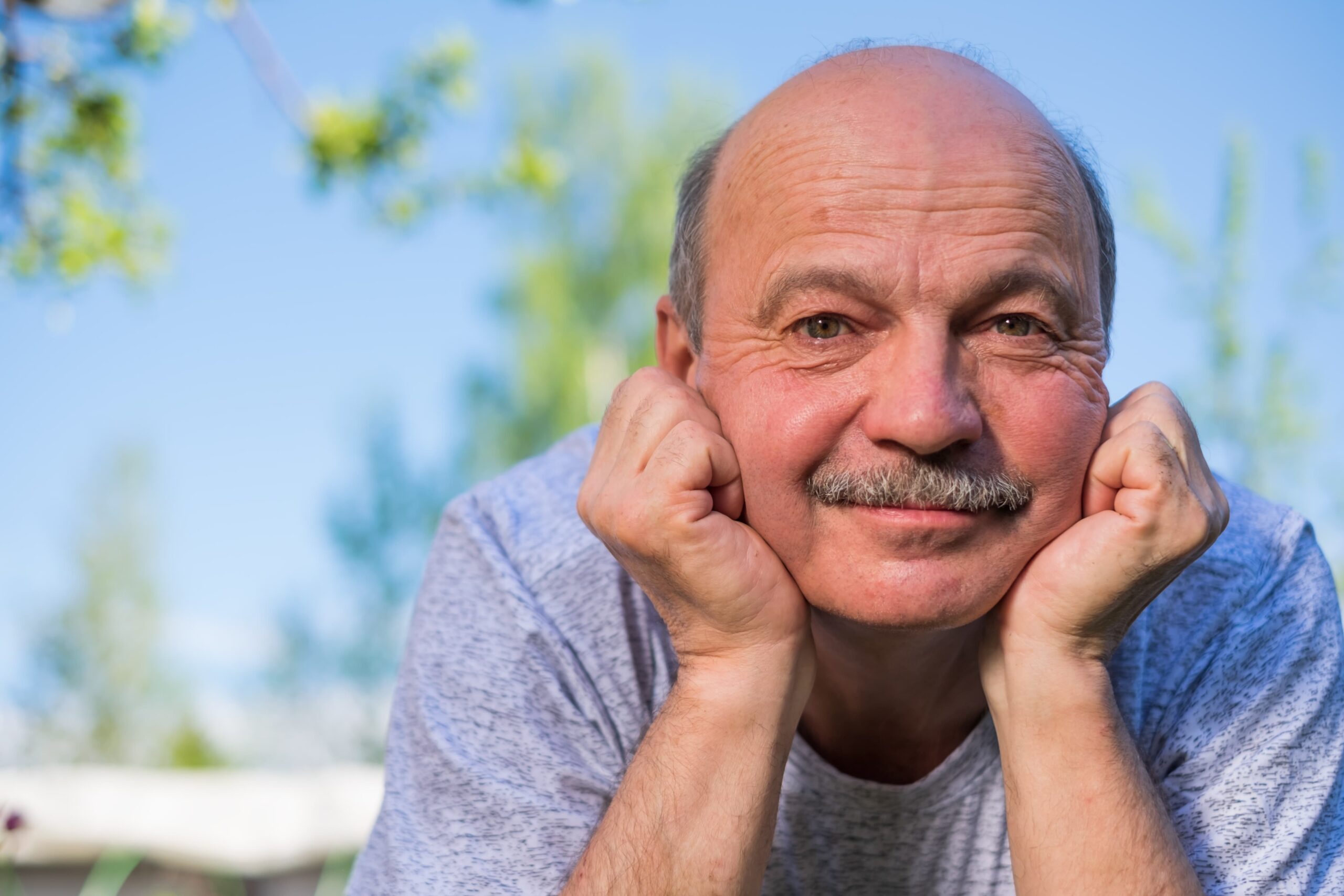 Senior man with his hands under his chin