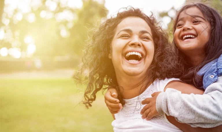 Happy Indian mother having fun with her daughter outdoors